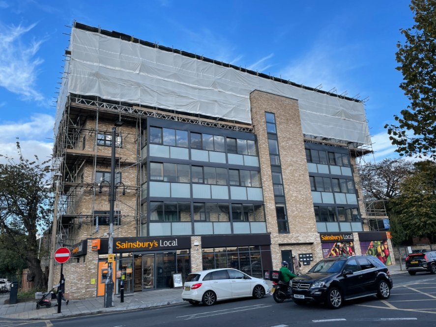 Sheeted commercial scaffold above a Sainsbury's Local